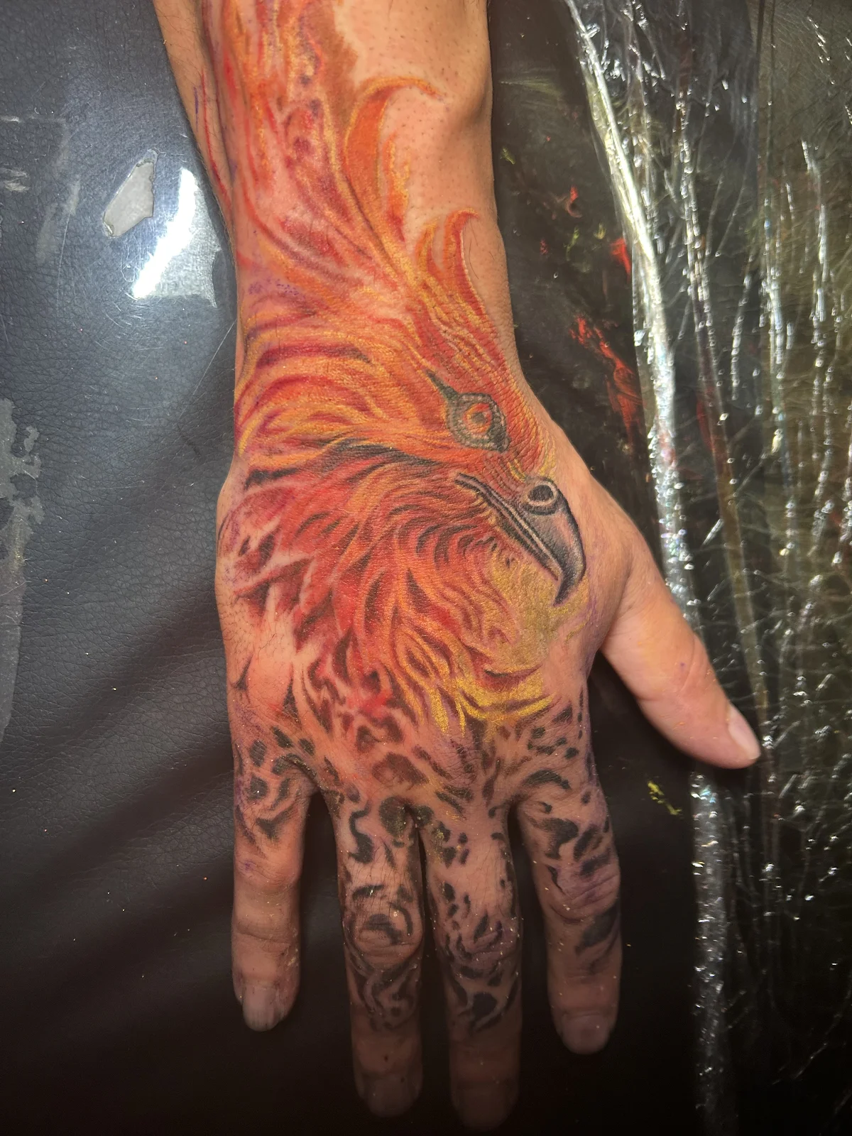 Color phoenix hand tattoo — cover-up and integration work, Work of Art Las Vegas