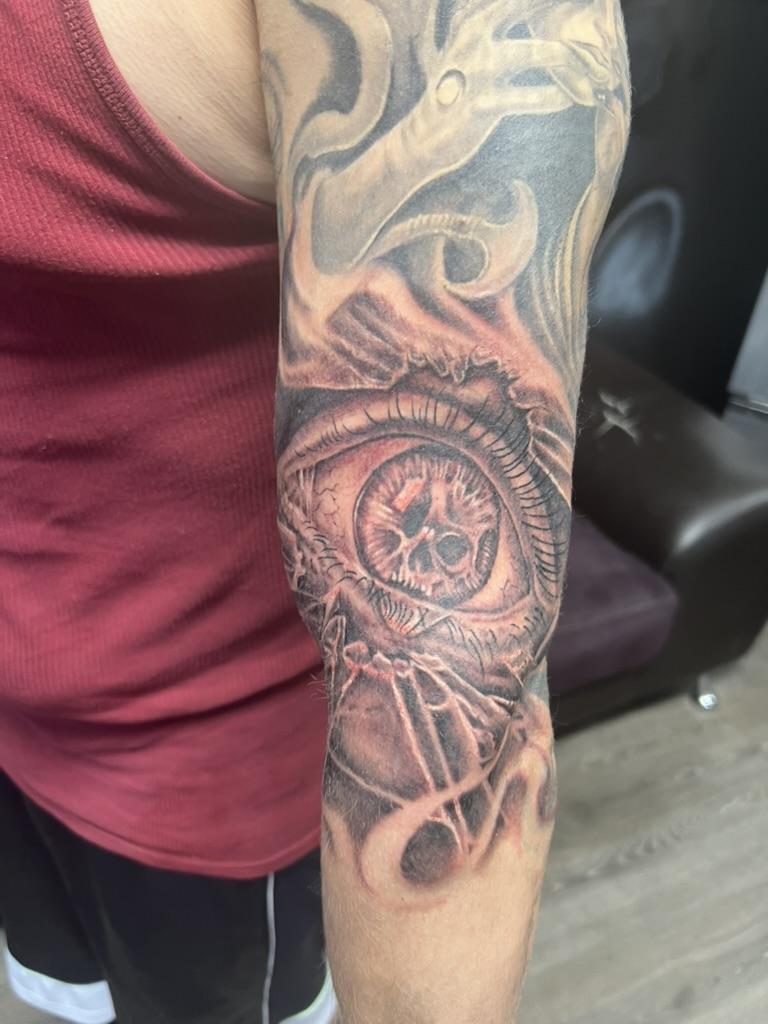 Fresh black and grey all-seeing eye skull elbow tattoo by Joshua Cole, Las Vegas