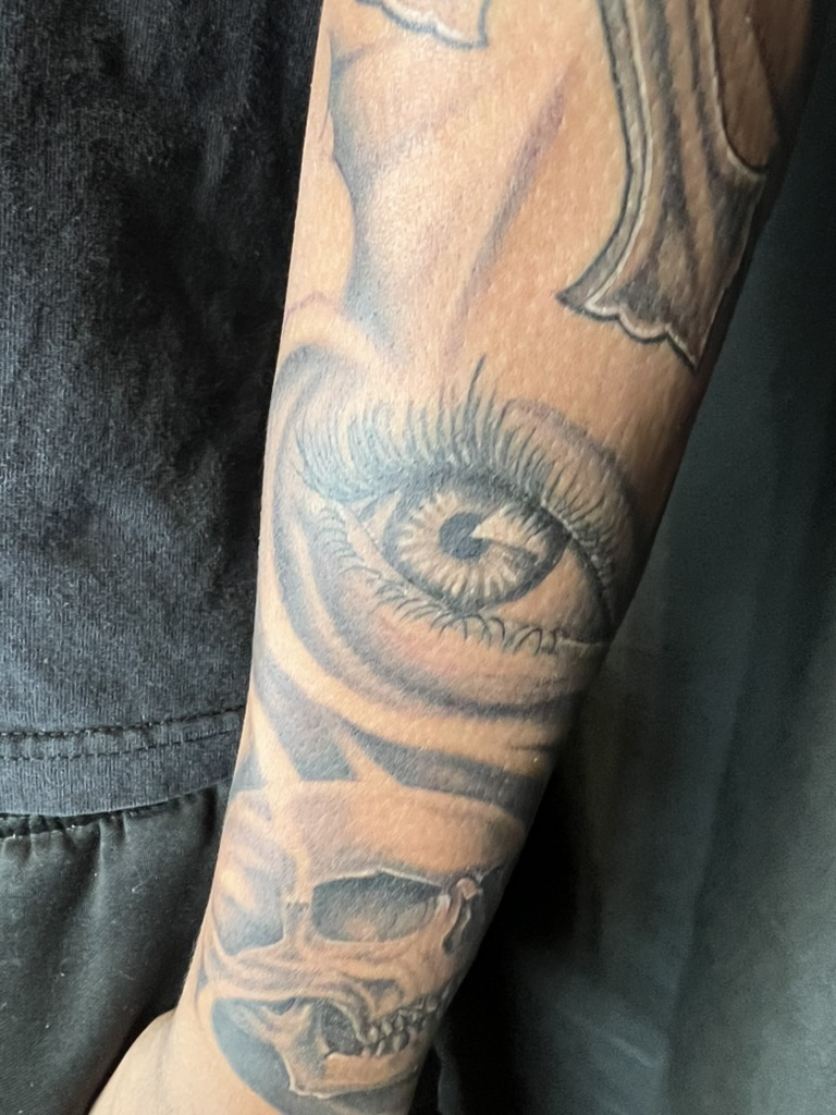 Healed one year realistic eye and skull black and grey forearm tattoo by Joshua Cole, Work of Art Las Vegas