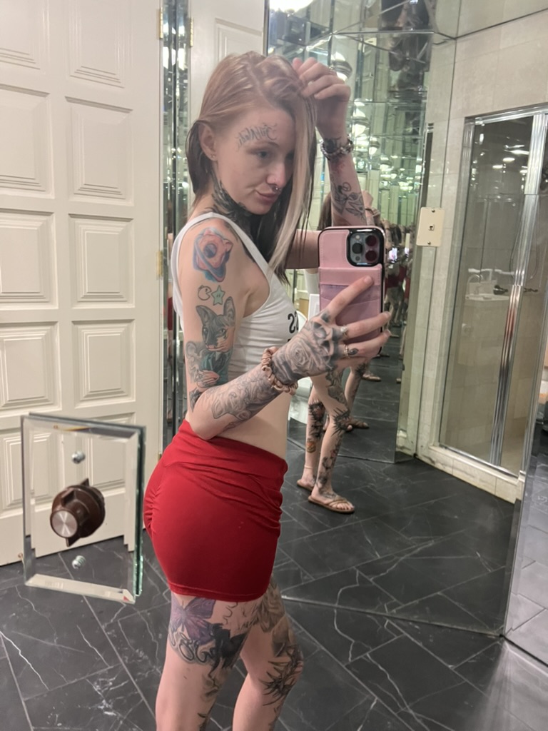 Heavily tattooed client mirror selfie showing rose hand tattoo and purple butterfly offsite — Joshua Cole offsite booking, Work of Art Las Vegas