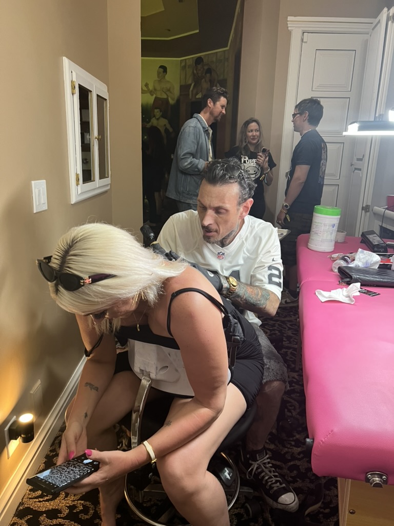 Joshua Cole tattooing at private event — portable setup with professional lighting
