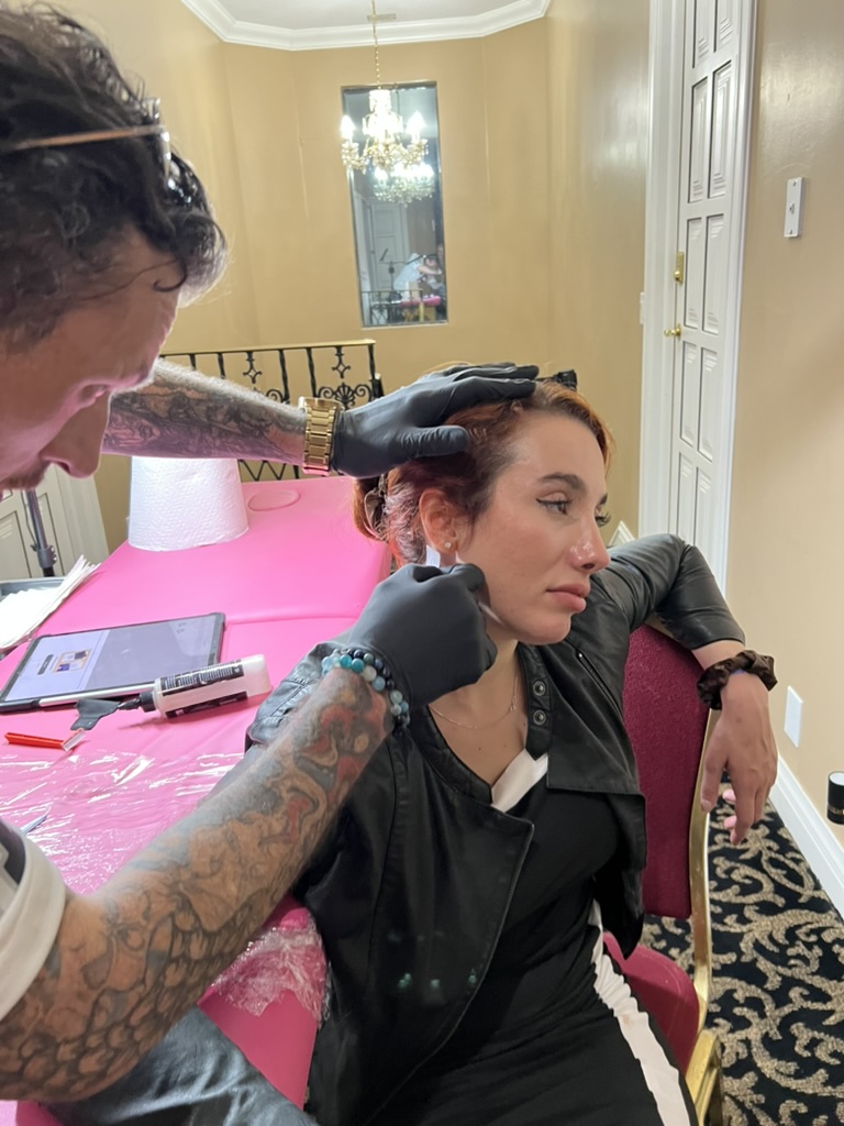 Joshua Cole tattooing client's hand at private residence — offsite booking Work of Art Las Vegas