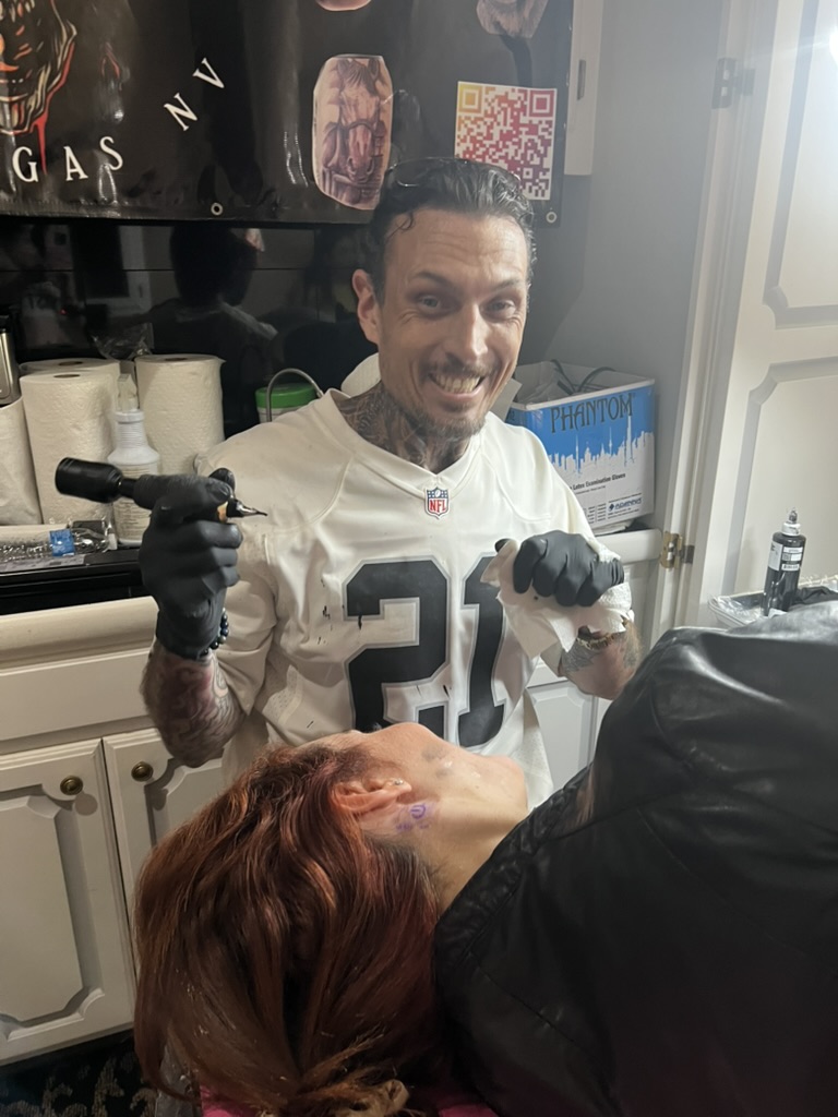 Joshua Cole tattoos jawline stencil on red-haired client in #21 jersey — Joshua Cole offsite booking, Work of Art Las Vegas