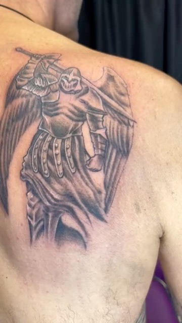 Black and grey armored archangel with wings and sword on upper back. — Joshua Cole, Work of Art Las Vegas