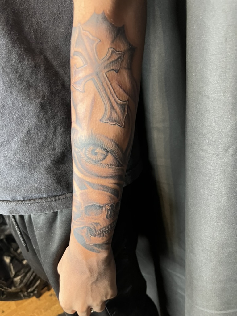 Full forearm cross, eye, and skull sleeve on darker skin tone. — Joshua Cole, Work of Art Las Vegas
