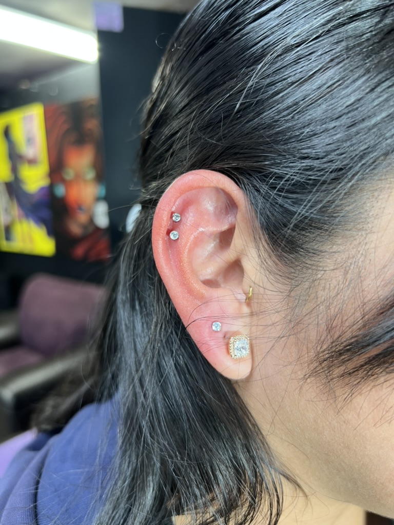Ear curated with twin helix crystals, gold tragus hoop and square-cut lobe stud in studio — Joshua Cole, Work of Art Las Vegas