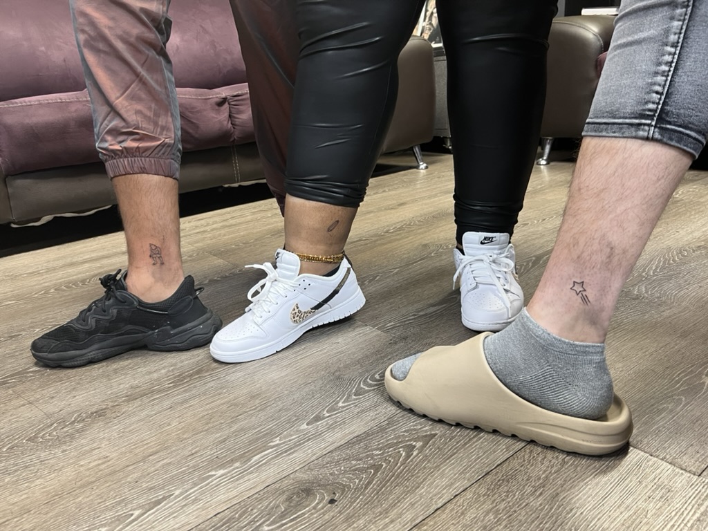 Three clients display fine-line ankle tattoos of a figure, pin, and star. — Joshua Cole, Work of Art Las Vegas