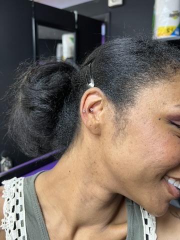 Side profile of smiling woman with new flat helix and conch crystal studs in studio — Joshua Cole, Work of Art Las Vegas