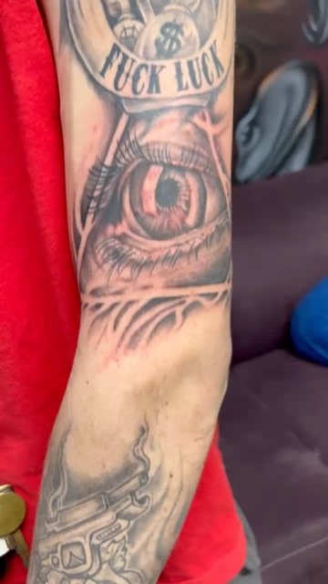 Hourglass with money bags, eye, and smoking pistol sleeve on upper arm. — Joshua Cole, Work of Art Las Vegas