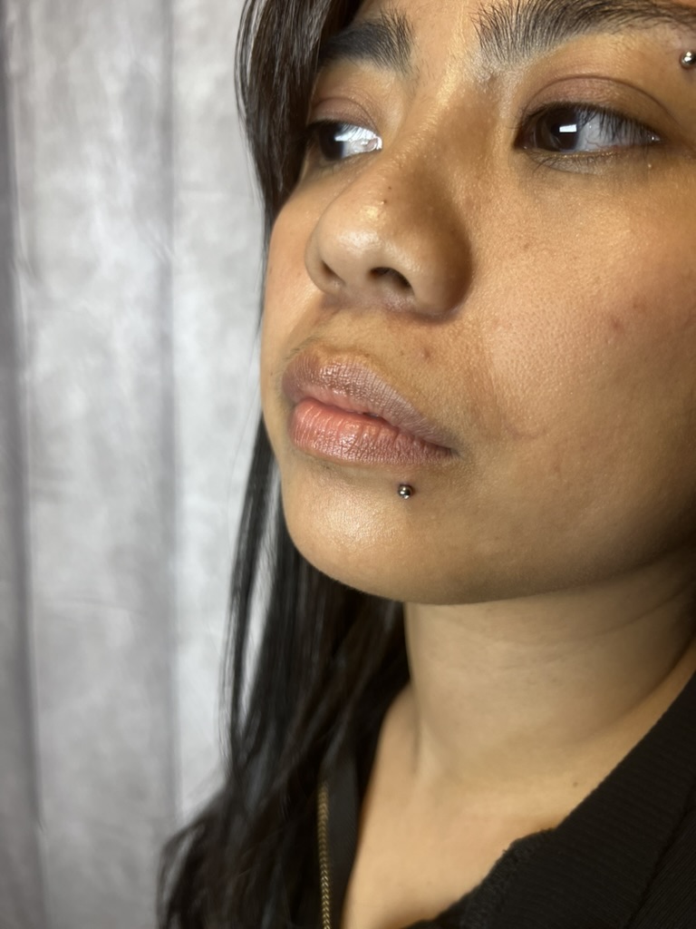 Close three-quarter portrait showing silver labret below lip and matching eyebrow stud — Joshua Cole, Work of Art Las Vegas