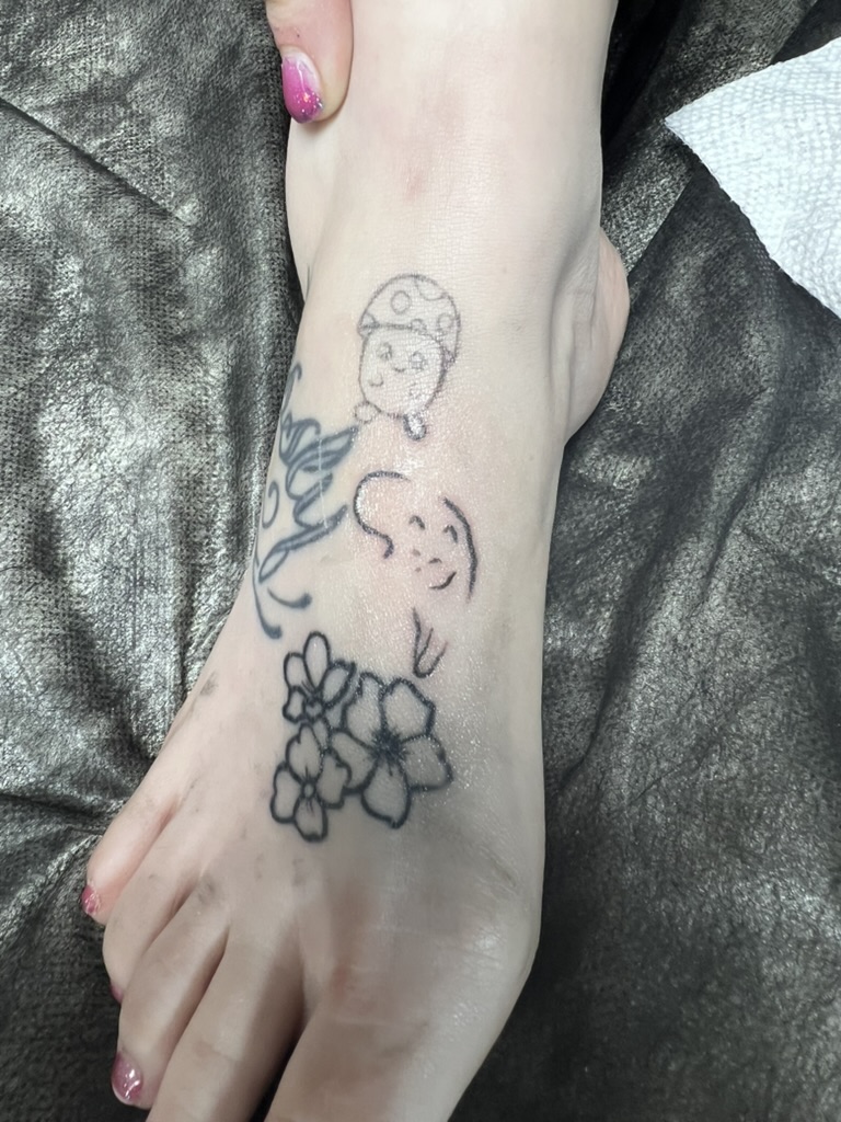 Whimsical mushroom, ghost, and cherry blossom fine-line foot tattoos. — Joshua Cole, Work of Art Las Vegas