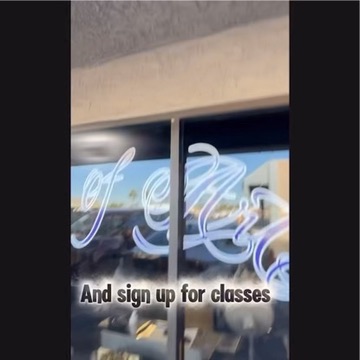 Glass storefront cursive of Art lettering looking out to parking lot, sign up for classes — Joshua Cole, Work of Art Las Vegas