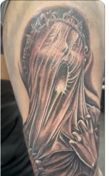 Black-grey veiled woman with ornate crown clutching fabric on upper arm, halo backdrop — Joshua Cole, Work of Art Las Vegas